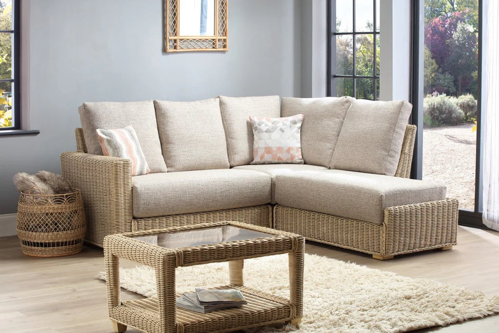 Beige sectional sofa with wicker coffee table in a living room setting.