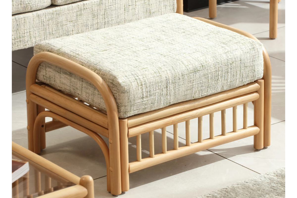 Rattan ottoman with a cushion on a tiled floor